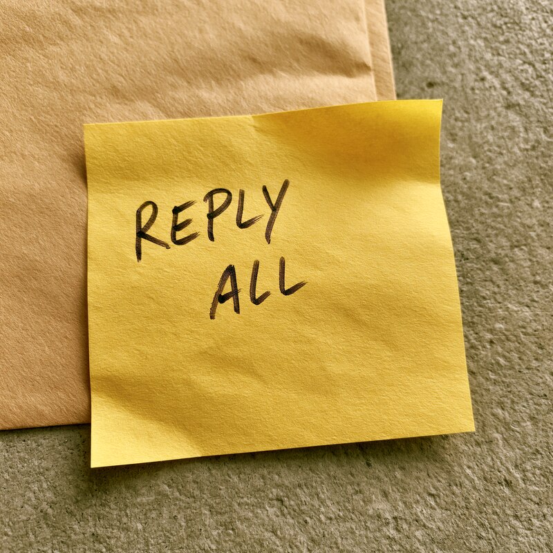 A desk note that reads reply all